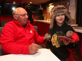 Carter Reimer, 7, shows off his Chicago Black Hawks' jersey signed by former-NHLer Dennis Hull at Red River Exhibition Park on Dec. 11, 2012, in Winnipeg.