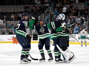 Spencer Martin of the Vancouver Canucks is congratulated by teammates after they beat the San Jose Sharks in overtime at SAP Center on Wednesday.
