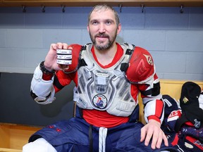 Alex Ovechkin of the Washington Capitals poses with the pucks from his 798th, 799th and 800th career goal after the game at United Center on December 13, 2022 in Chicago, Illinois.