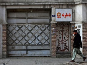 An Afghan man walks past the office of a foreign aid group 'Care' in downtown Kabul, Monday, Dec. 26, 2022. Several foreign aid groups announced on Saturday, Dec. 25 they were suspending their operations in Afghanistan after the country's Taliban rulers ordered all NGOs to stop women staff from working.