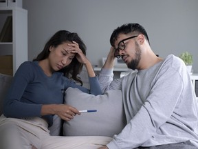 Couple feeling sad and disappointed with results of a pregnancy test