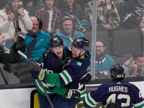 Elias Pettersson, left, celebrates with and Quinn Hughes after scoring a goal against the San Jose Sharks during overtime in an NHL hockey game in San Jose on Wednesday.