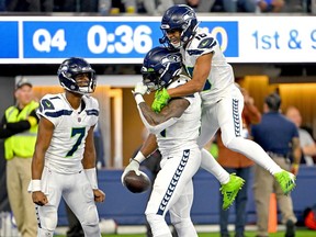 Seattle Seahawks wide receiver Tyler Lockett (16) celebrates with quarterback Geno Smith (7) and wide receiver DK Metcalf (14) after a touchdown in the fourth quarter against the Los Angeles Rams at SoFi Stadium.
