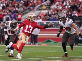 San Francisco 49ers quarterback Brock Purdy (13) scores a touchdown in front of Tampa Bay Buccaneers linebacker Anthony Nelson (98) and linebacker Devin White (45) in the second quarter at Levi's Stadium.