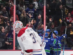 Vancouver Canucks’ Ilya Mikheyev, back, Brock Boeser, back right, and Elias Pettersson celebrate Mikheyev’s goal against Montreal Canadiens goalie Sam Montembeault during the third period on Monday.