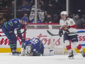 Vancouver Canucks' Tyler Myers (57) checks on goalie Thatcher Demko (35) as he lies on the ice after being injured as Florida Panthers' Ryan Lomberg (94) celebrates his goal during the first period of an NHL hockey game in Vancouver, on Thursday, December 1, 2022.