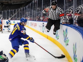 FILE PHOTO: Sweden's Jonathan Lekkerimaki (24) handles the puck as the referee jumps out of the way during the second period of the IIHF World Junior Hockey Championship semifinal in Edmonton, Friday, Aug. 19, 2022.
