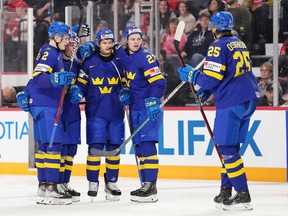 Sweden’s Simon Robertsson, centre, celebrates his goal with Canucks prospect Elias Pettersson, left, Ludvig Jansson, Oskar Pettersson, and Milton Oscarsson (right) during the second period IIHF World Junior Hockey Championship hockey action against Austria in Halifax on Monday.