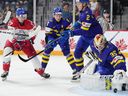 Sweden goalkeeper Carl Lindbom, right, makes a save as teammates Victor Sjoholm, second from left, and Elias Pettersson keep out Czech Republic's Petr Hauser during the first period in Halifax on Thursday.