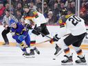 Sweden's Jonathan Lekkerimaki, left, fights for the puck with Germany's Adrian Klein, centre, and Veit Oswald during the third period in IIHF World Junior Hockey Championship hockey action in Halifax on Tuesday.