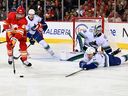 Calgary Flames forward Nazem Kadri (91) gets control of the puck against Vancouver Canucks defenseman Ethan Bear (74) in the first period at Scotiabank Saddledome Dec 31, 2022.