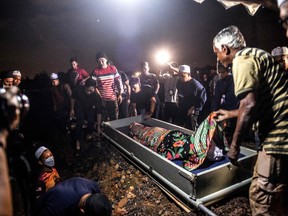 Body of a landslide victim, Nurul Azwani Kamarulzaman, lie on the ground during a burial ceremony at Raudhatul Sakinah cemetery in Kuala Lumpur on Dec. 17, 2022.