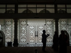 A imam explains Islamic beliefs and teachings to visitors at the Crystal Mosque in Kuala Terengganu, Terengganu, Malaysia, on Monday, July 23, 2017. With a federal election due within 12 months, Prime Minister Najib Razak's United Malays National Organisation is seeking to burnish its credentials with Muslim voters in the conservative Islamic northeastern state.