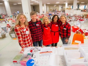 From left to right: Michelle Varley, Julia Staub-French, Bev Montgomery, Nawaz Daruwala and Jill Johnston are volunteers putting together all the gift baskets for the North Shore Christmas Bureau.