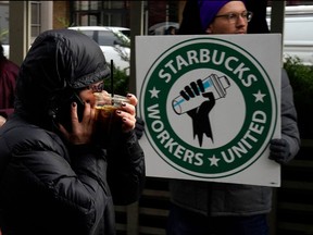 A person walks past a Starbucks Workers Union strike outside a Starbucks coffee shop in the Chelsea neighbourhood of New York City on Nov. 17, 2022.