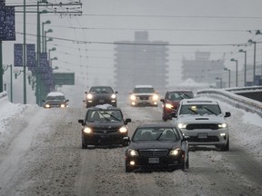 Motorists travel on the snow-covered Cambie Bridge as freezing rain falls in Vancouver, on Friday. Photo: Darryl Dyck/CP
