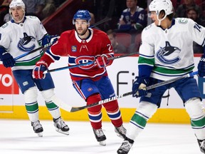 Jonathan Drouin z Montreal Canadiens, lewy skrzydłowy, obserwuje lewego skrzydłowego Vancouver Canucks Tannera Pearsona i Ethana Beera z Vancouver Canucks, prawy, podczas turnieju NHL w Montrealu w środę, 9 listopada 2022 r.