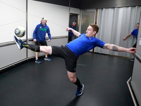 Travis Dermott of the Vancouver Canucks kicks a soccer ball as he warms up before an NHL game against the Ottawa Senators at Rogers Arena on April 19, 2022.