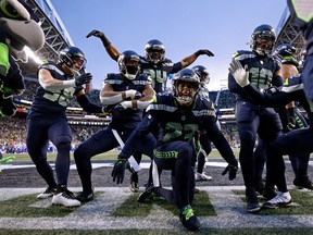 The Seattle Seahawks celebrate an interception by Quandre Diggs #6 against the Los Angeles Rams during overtime at Lumen Field on January 08, 2023 in Seattle, Washington.