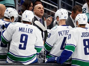 Head coach Rick Tocchet of the Vancouver Canucks gathers his team during the first period against the Seattle Kraken at Climate Pledge Arena on Wednesday in Seattle.