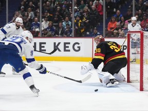 Tampa Bay Lightning's Steven Stamkos, left, scores against Vancouver Canucks goalie Spencer Martin, to record his 500th career goal during first period NHL hockey action in Vancouver on Wednesday, Jan. 18, 2023.