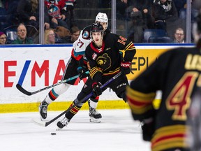 Ethan Semeniuk of the Vancouver Giants tries to pull away from the Kelowna Rockets' Dylan Wightman during Vancouver's 4-3 win in Kelowna on Saturday