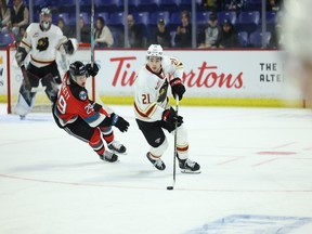 Dylan Anderson of the Vancouver Giants tries to pull away from Logan Peskett of the Kelowna Rockets on Friday at the Langley Events Centre.