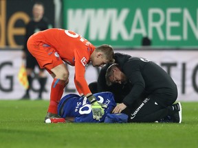 Salif Sane of Schalke receives medical treatment during the Bundesliga match between FC Augsburg and FC Schalke 04 at WWK-Arena in November 2019 in Augsburg, Germany.