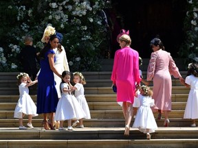 Britain's Catherine, Duchess of Cambridge (L) and Meghan Markle's friend, Canadian fashion stylist Jessica Mulroney (2L) holds bridesmaids hands as they arrive for the wedding ceremony of Britain's Prince Harry, Duke of Sussex and US actress Meghan Markle at St George's Chapel, Windsor Castle, in Windsor, on May 19, 2018. (Photo credit: BEN STANSALL/AFP via Getty Images)