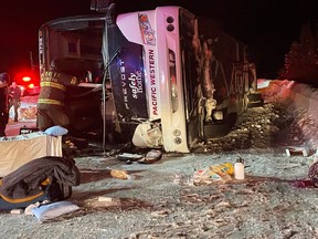 First-responders look over the scene of a bus crash on Highway 97C, the Okanagan Connector between Merritt and Kelowna, on Dec. 24, 2022.