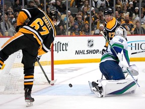 Pittsburgh Penguins' Rickard Rakell (67) puts a shot behind Vancouver Canucks goaltender Spencer Martin (30) for a goal during the second period.