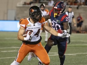 B.C. Lions fullback David Mackie (34) protects the ball from Montreal Alouettes Jeshrun Antwi (20) during first half CFL football action in Montreal on Friday, September 9, 2022. Mackie signed a two-year contract extension with the B.C. Lions on Wednesday.