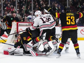 Vancouver Canucks' Dakota Joshua (81) is checked into Chicago Blackhawks goalie Petr Mrazek by Max Domi (13) after scoring a goal during the third period at Rogers Arena on Tuesday night.