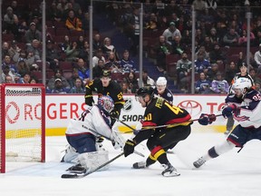 Vancouver Canucks' Elias Pettersson  scores against Columbus Blue Jackets goalie Joonas Korpisalo as Kirill Marchenko defends during the first period of an NHL hockey game in Vancouver, on Friday, January 27, 2023.