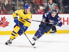 Sweden's Elias Pettersson looks up the ice to make a pass as Finland's Lenni Hameenaho chases the second period of the IIHF World Junior Hockey Championships quarterfinal in Moncton, NB, on January 2, 2023.