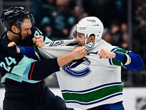 Seattle Kraken defenceman Jamie Oleksiak, left, and Vancouver Canucks defenceman Luke Schenn duke it out at Climate Pledge Arena.