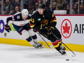 Columbus Blue Jackets forward Mathieu Olivier (24) pursues Vancouver Canucks defenseman Quinn Hughes (43) in the second period at Rogers Arena on Jan. 27, 2023.