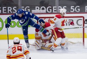 Calgary Flames defenseman Mark Giordano (5) and Vancouver Canucks forward Bo Horvat (53) collide with goalie Jacob Markstrom (25) in the first period at Rogers Arena. Mandatory Credit: Bob Frid-USA TODAY