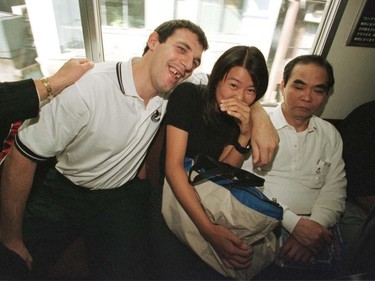 Vancouver Canucks Gino Odjick cuddles up to a stranger as he rides the Tokyo subway to practise.