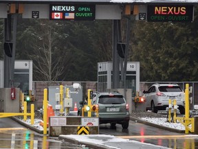 A motorist scans a Nexus card as another speaks with a Canada Border Services Agency officer at a primary inspection booth at the Douglas-Peace Arch border crossing in Surrey, B.C., on Wednesday February 5, 2020. Canadian and U.S. border agencies say they have a plan to reduce the backlog for the Nexus trusted-traveller program.