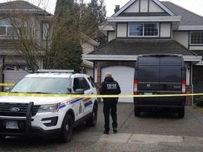 The Integrated Homicide Investigation Team (IHIT) have a Surrey home behind police tape on Jan. 10, 2023, after three bodies were discovered inside.