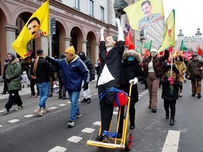 Participants wave flags showing the face of Abdullah Ocalan, the leader of the Kurdistan Worker's Party (PKK) and march with an effigy of Turkish President Recep Tayyip Erdogan in Stockholm on January 21, 2023.