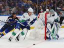 Ethan Bear of the Vancouver Canucks controls the puck against Robert Thomas of the St. Louis Blues as Arturs Silovs of the Vancouver Canucks looks on in the first period at Enterprise Center on February 23, 2023 in St Louis, Missouri.