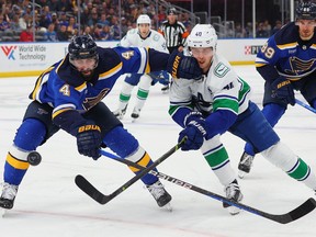 Nick Leddy of the St. Louis Blues looks to beat Elias Pettersson of the Vancouver Canucks to the puck in the second period at Enterprise Center on February 23, 2023 in St Louis, Missouri.