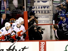 Calgary Flames head coach Robert Hartley (left) and Vancouver Canucks’ head coach John Tortorella (right) exchange words during the first period of NHL game at Rogers Arena in Vancouver, B.C. on Saturday January 18, 2014.