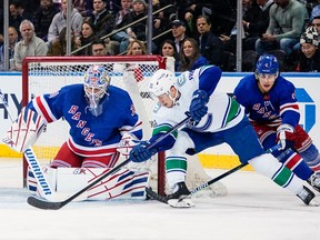 New York Rangers goaltender Igor Shesterkin (31) stops a shot on goal by Vancouver Canucks' Curtis Lazar as Braden Schneider (4) defends during the second period on Wednesday night.