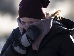 A person tries to stay warm as they walk in downtown Ottawa, Friday, Feb. 3, 2023.