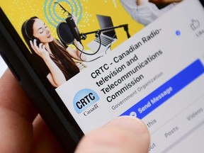 A person navigates to the on-line social-media pages of the Canadian Radio-television and Telecommunications Commission (CRTC) on a cell phone in Ottawa on May 17, 2021.
