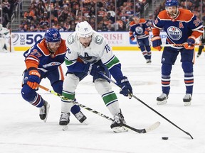 Vancouver Canucks' Tanner Pearson (70) and Edmonton Oilers' Brett Kulak (27) battle for the puck during first period NHL action in Edmonton on Wednesday, October 12, 2022. The Canucks have placed left-winger Pearson on long-term injured reserve due to a season-ending hand injury.