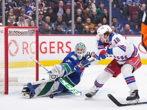 Canucks rookie goalie Arturs Silovs sprawls to stop New York Rangers winger Artemi Panarin on a breakaway during Wednesday's game — Silovs' first ever NHL regular season appearance — at Rogers Arena.
